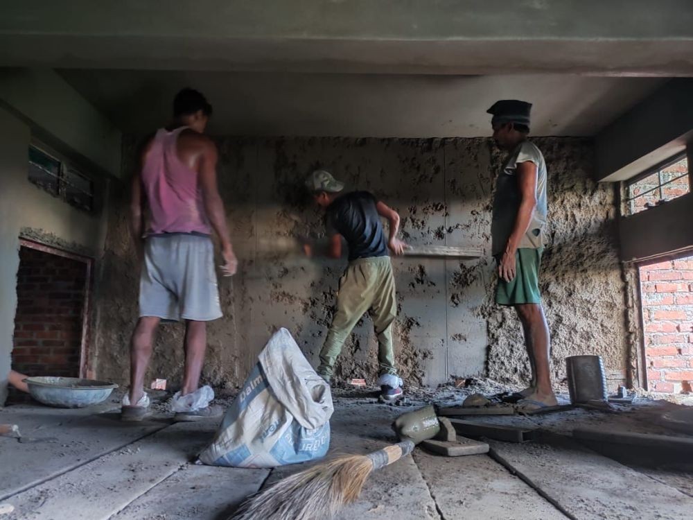 Migrant construction workers in the process of plastering the wall of a under construction building in Niuland district area. (Morugn Photo)